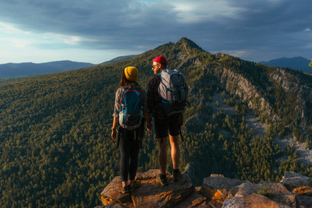 Travelers on the background of autumn mountains. mountain tourism. Walking tour of the autumn mountains. A trip to the mountains with a backpack. A couple in love against the background of mountainsの写真素材