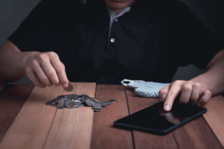 The man check his grow business on phone, growth coin loan saving and finance concept on the wood background business and finance conceptの写真素材