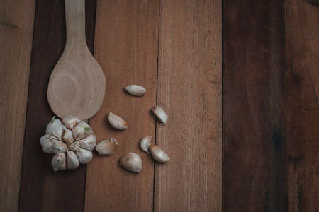 Fresh garlic on the wood background, and spoon food concept, healthy and nature food, close up shot...