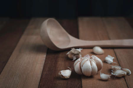 Fresh garlic on the wood background, and blurred spoon food concept, healthy and nature food, close...