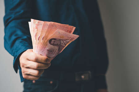 A man hands with thailand coin and cash, business and investment concept, finance and banking and related, copy space for textの写真素材