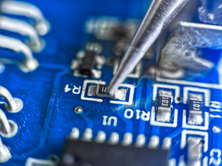 Damaged electronic board during repair with a soldering ironの写真素材