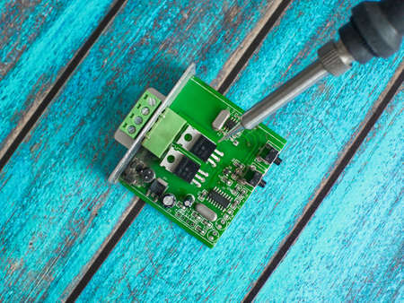 Damaged electronic board during repair with a soldering ironの写真素材