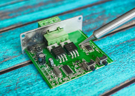 Damaged electronic board during repair with a soldering ironの写真素材