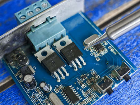 Damaged electronic board during repair with a soldering ironの写真素材