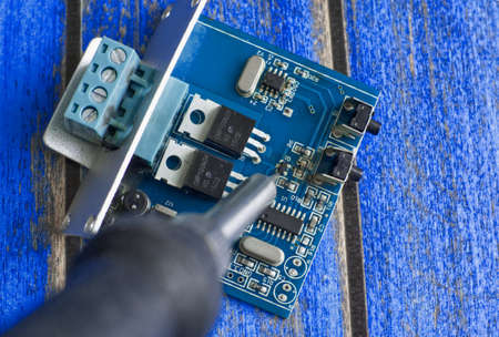 Damaged electronic board during repair with a soldering ironの写真素材