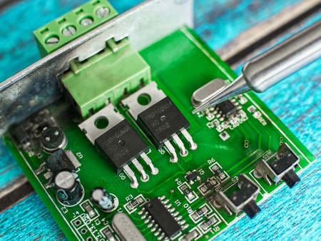Damaged electronic board during repair with a soldering ironの写真素材