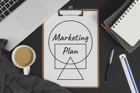 Marketing Plan written on white paper placed with laptop computer. Business and marketing concept.の写真素材