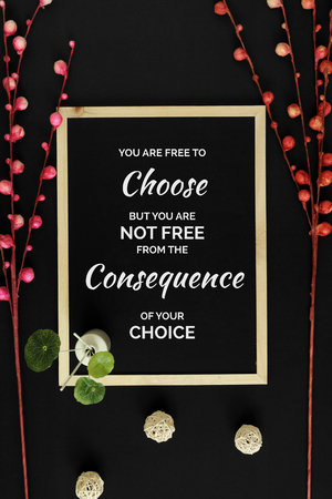 Motivational and inspirational quote. Wisdom quote. Wood frame with flowers on black background with quote. Oriental minimal flat lay.の写真素材