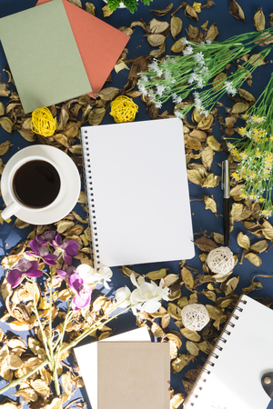 Notepad and coffee on rustic blue background with dry flower petals. Rustic nostalgia.の写真素材