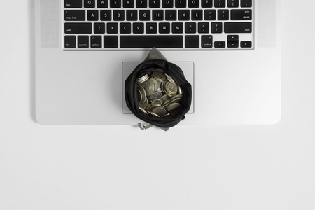 Sack of coins on top of notebook laptop. Financial business management concept.の写真素材