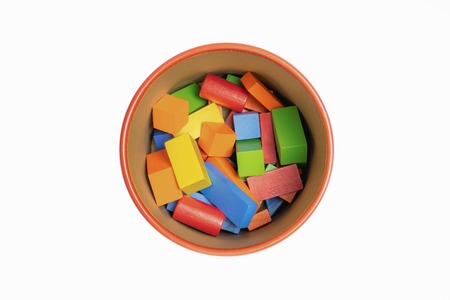 Colorful wooded toy blocks in bucket isolated on white background. Top view.の写真素材