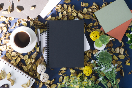 Notepad and coffee on rustic blue background with dry flower petals. Rustic nostalgia.の写真素材