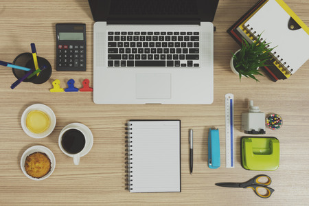Multiple stationery items for office and school and a laptop. Office supply on wood background.の写真素材