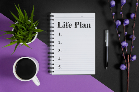 Life plan list. Notebook and coffee on purple and black background.の写真素材