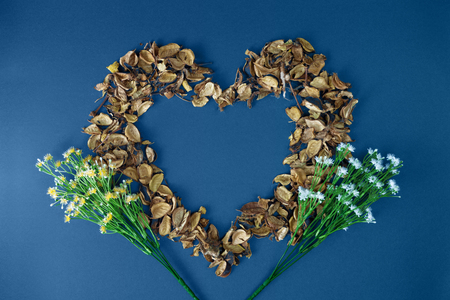 Heart shaped dry petals on blue background. Rustic nostalgia.の写真素材