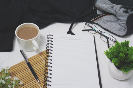 Blank spiral notebook page on cozy white tablecloth. Rustic home office desk.の写真素材