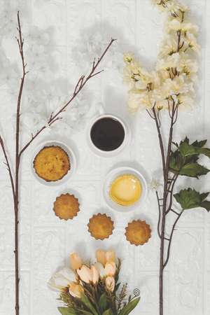 Coffee and cakes on white brick background. Rustic nostalgia cozy breakfast.の写真素材