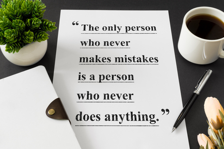 Wisdom quote on white paper with coffee cup and diary on desk.の写真素材