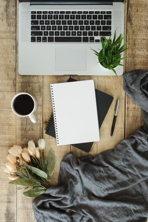 Laptop with notebook and coffee cup on rustic old wood background.の写真素材