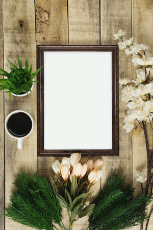Wood picture frame and coffee with flower decoration on wood background. Rustic nostalgia flat lay.の写真素材