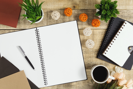 Notebook, diary and coffee with flower decoration on wood background. Rustic nostalgia flat lay.の写真素材