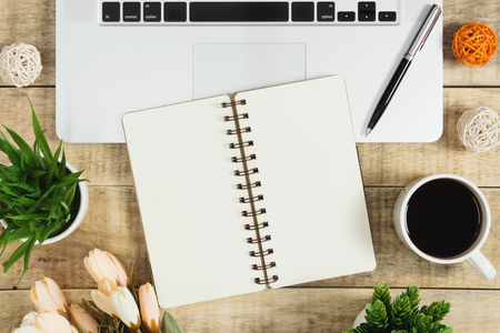 Notebook on top of laptop with coffee on wood background. Rustic nostalgia flat lay.の写真素材