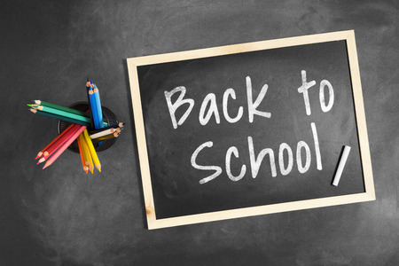 Back to School written on blackboard with multiple colorful colored pencil inside a pencil holder.の写真素材