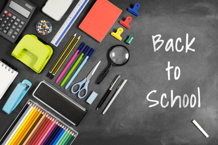 Back to School written on blackboard with multiple stationery items.の写真素材