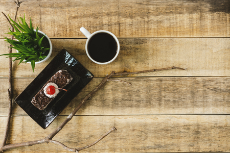 Butterscotch cake and cup of coffee on rustic wood. Flat lay.の写真素材
