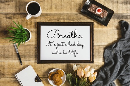 Wood frame with wisdom quote and breakfast food on rustic wood. Flat lay with text copy space.の写真素材