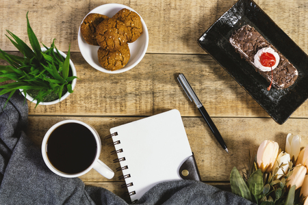 Diary, cookies and cup of coffee on rustic wood. Flat lay.の写真素材