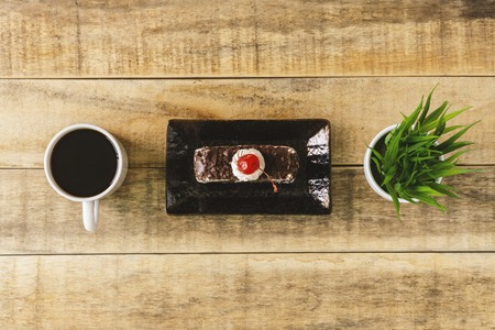 Butterscotch cake and cup of coffee on rustic wood. Flat lay.の写真素材