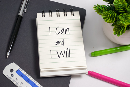 Notebook with wisdom quote on top of office desk.の写真素材