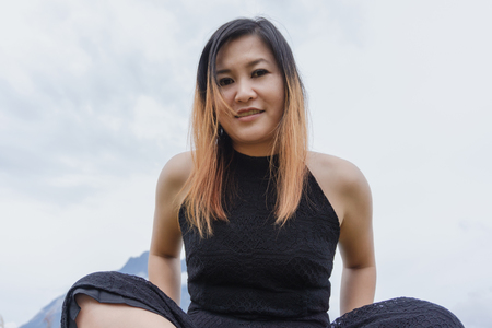 Young adult Asian woman sitting and smiling.の写真素材