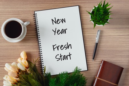 Notepad with wish list and coffee cup. New year's hope and resolution concept - New Year, Fresh Start.の写真素材