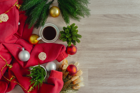 Red sweater, coffee and ornament balls decoration on wood table. Merry Christmas and holiday concepts.の写真素材