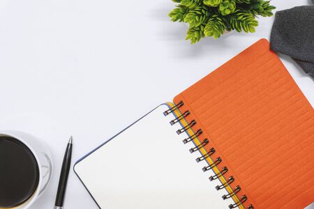 Overhead view of notebook on white desk.の写真素材