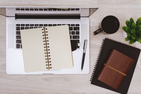 Overhead view of laptop, open notebook and coffee mug on table.の写真素材