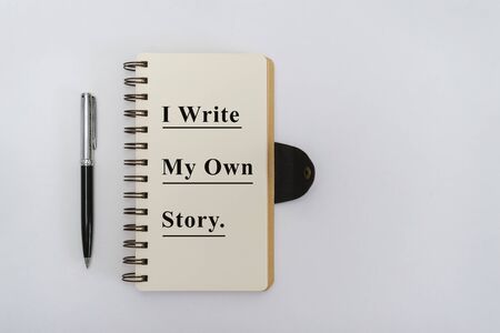 Overhead View of Notebook with Motivational Quote and Pen on White Backgroundの写真素材