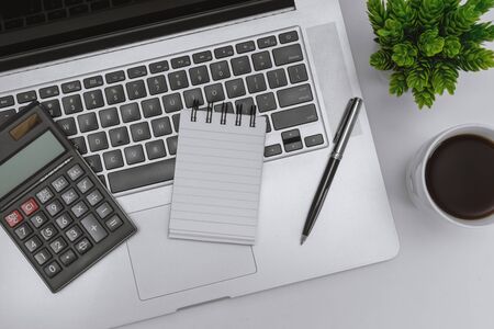 Overhead View of Laptop, Notebook and Calculator on Work Deskの写真素材