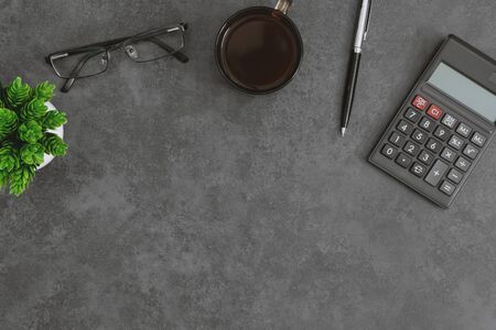 Overhead view of work desk with calculator, coffee cup, eyeglasses pen and potted plant.の写真素材