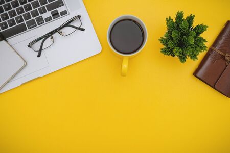 Overhead View of Laptop and Coffee Mug on Yellow Background