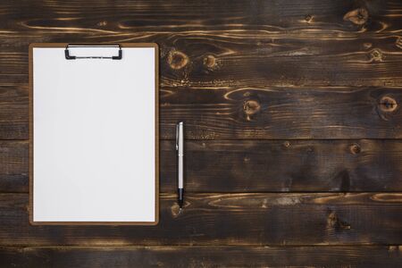 Overhead view of Clipboard and Pen on Rustic Woodの写真素材