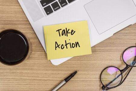Overhead View of Take Action. Sticky Note and Laptop on Wooden Work Deskの写真素材