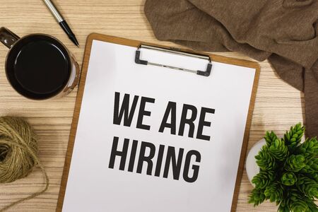 Overhead View of We Are Hiring Announcement on Clipboardの写真素材