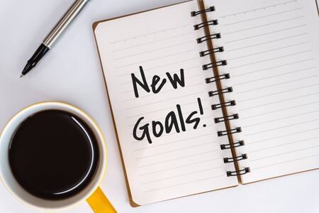 New Goals. Spiral Notebook with Inspirational and Motivational Quote on White Desk.の写真素材