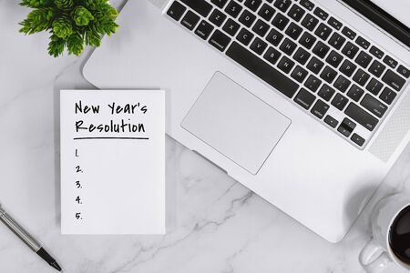 New Year's Resolution List on Notebook With Laptop Over Work Desk.の写真素材