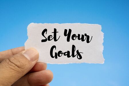 Inspirational and Motivational Quote. Hand Holding Paper. Set Your Goals. Blue Sky Background.の写真素材