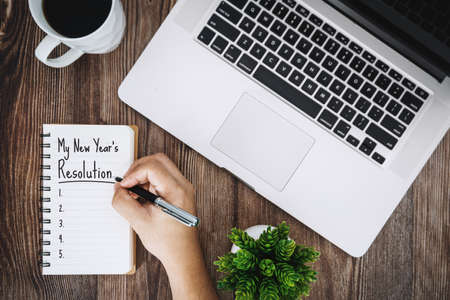 My New Year's Resolution on Notebook over Wooden Work Deskの写真素材
